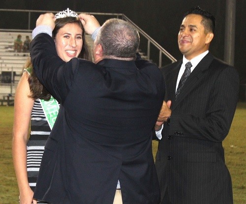 Snook Christian Academy Head of School Thad Butts crowns the school's first-ever Homecoming Queen Alexa Lopez as father Jonathan Lopez looks on.