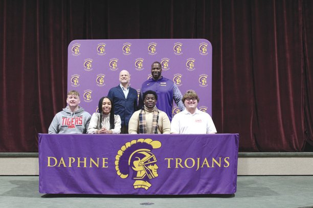 Daphne High School Principal Fletcher Comer and Athletic Director Kenny King pose for photos with (from left) Taylor Hicks, Tiana Smith, Ashton Donald and Jacob Galmiche at the conclusion of the signing day celebration.