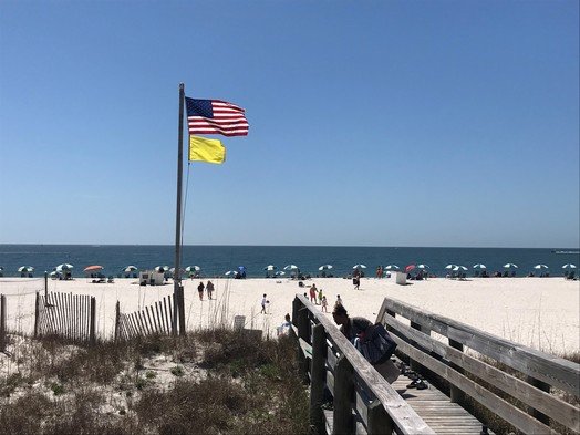 A yellow flag flies over the beach in Orange Beach on Tuesday, March 29. Yellow flags warn of moderate surf conditions. The new &quot;Beach Safe&quot; campaign was launched March 29 to educate the public about the meanings of flags and other beach safety measures.