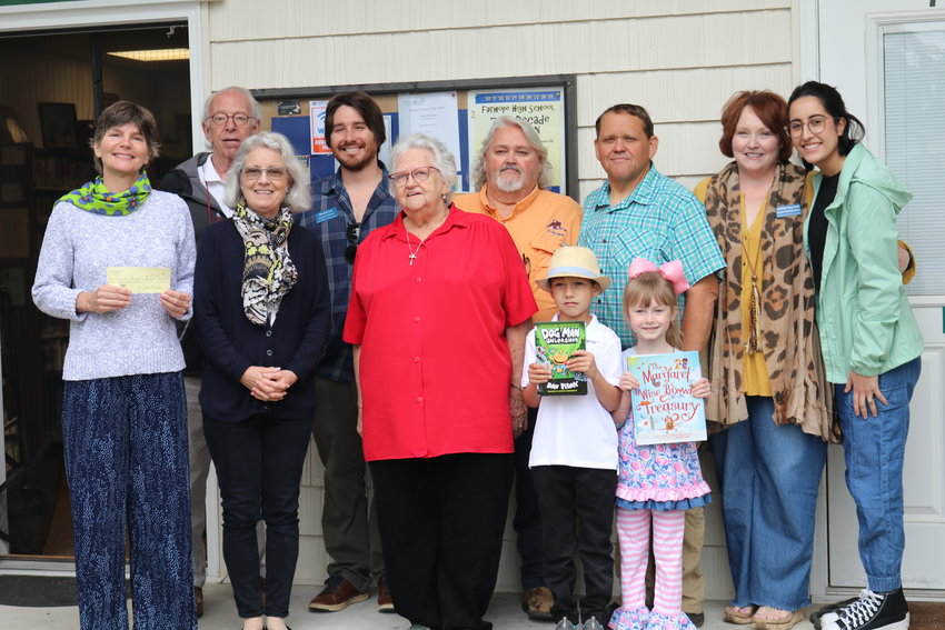 Pictured here, back row, from left: Library Board Treasurer Nick Shields, Library Board President Mitchell Lee, Harold Sherman, Clayton Sherman, Library Board Secretary Susan Bartholomew, and Library Board member Maritza Weeks.  Front row, from left: Library Director Paige Monaghan, Library Board member Ann Grandin, Barbara Sherman, Mason, and Mackenzie.