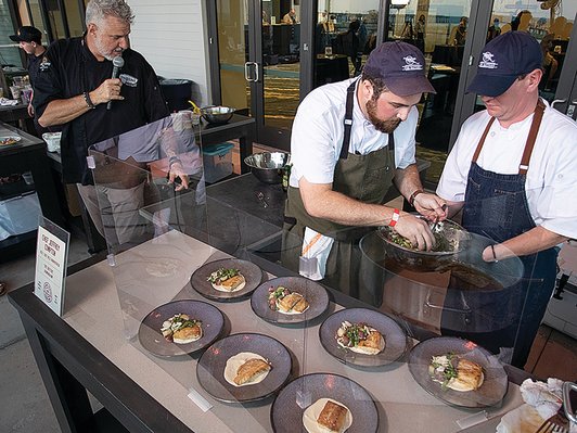 Chef Jeffrey Compton and assistant Kyle Kirkpatrick put the finishing touches on the winning dish at the Alabama Seafood Cook-Off at The Lodge at Gulf State Park.
