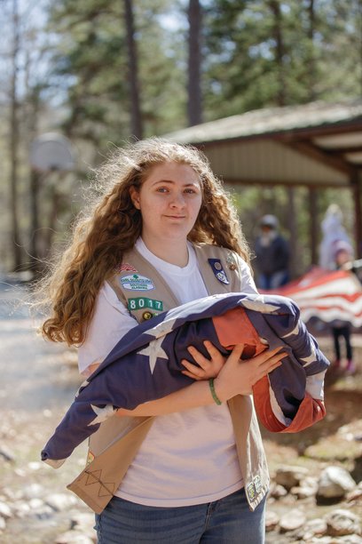 Girl Scout Ambassador Rachel Marlow holds a flag during a flag retirement ceremony earlier this year. The 2022 Fairhope High School graduate earned her Girl Scout Gold Award this year by creating donation boxes where the community could bring worn flags to be properly retired.