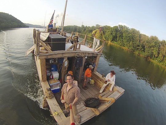 Crew members of &quot;The Patience,&quot; a flatboat, take a selfie as they move along the Mississippi River.