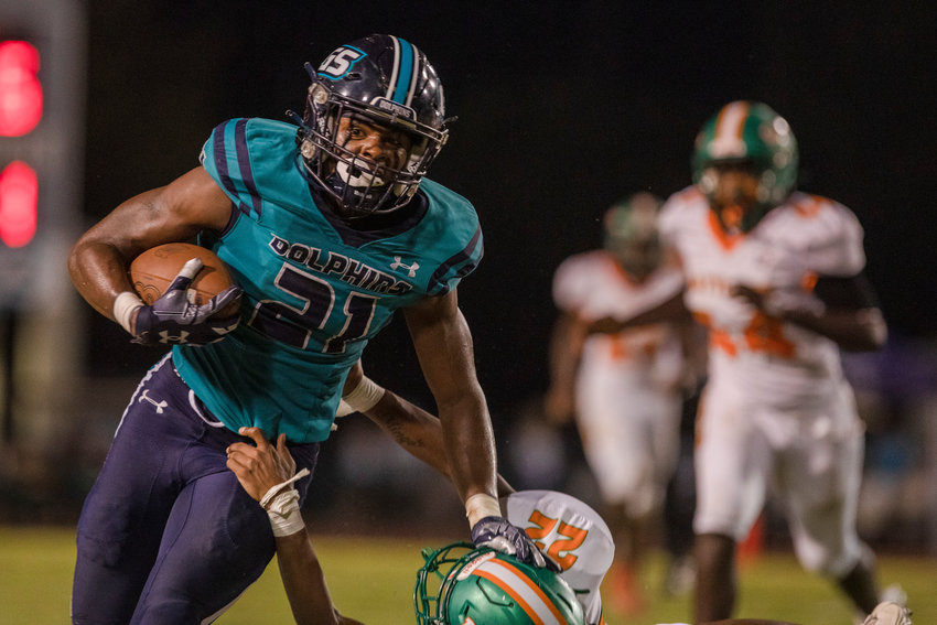 Gulf Shores senior JR Gardner delivers a stiff arm on a run during the Dolphins&rsquo; region game against the LeFlore Rattlers Sept. 16 at home. Gulf Shores won 45-12.
