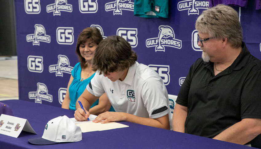 Gulf Shores senior Dominic Maldet puts pen to paper to cement his commitment to the Montevallo Falcons baseball program after his time with the Dolphins during Wednesday&rsquo;s signing ceremony at the high school.