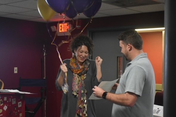 Jess Jackson, theater teacher at Daphne High School, reacts after receiving a $1,000 grant from SEEDS, Daphne's Education Foundation, to produce a new musical at the school. SEEDS board member Brandon Marcus is seen presenting the award.