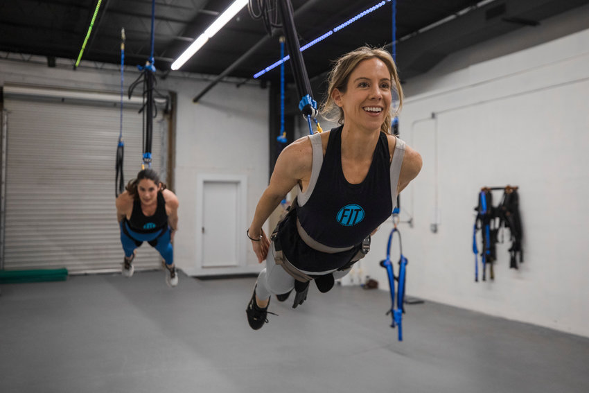 Jessica Watkins, owner of FIT Fairhope, leads Lauren Babcock in a Sling Bungee workout.