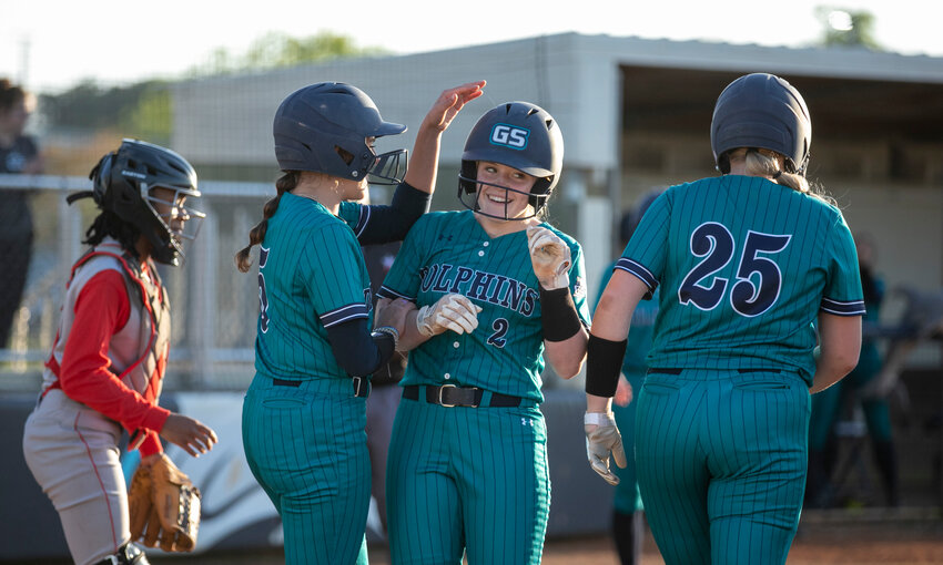 Gulf Shores eighth-grader Kayleigh Jacks celebrates her grand slam with freshman Anna-Leigh Price (5) and junior Emily Smith (25) during the Dolphins&rsquo; Class 5A Area 1 doubleheader against B.C. Rain at home March 21. The AHSAA South Regional championships are set to be held in Gulf Shores next weekend with spots in the state tournament on the line.