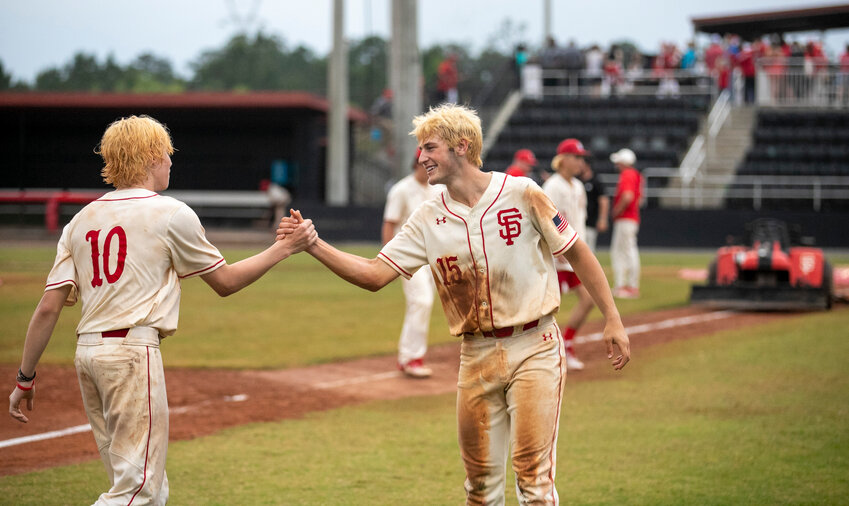 Brayden Cooper (10) and Newton Gardner (15) share an embrace after the Spanish Fort Toros&rsquo; walk-off win over Saraland Saturday, May 6, in the AHSAA state quarterfinals at home. Cooper provided the hit that scored Gardner to help Spanish Fort advance to its first semifinal series since 2015.