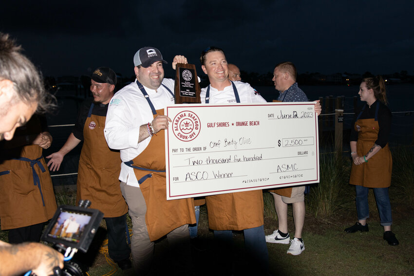 Chef Brody Olive and sous chef Luis Silvestre holding the check and plaque after being named the 8th Annual Alabama Seafood Cook-Off Champions Monday, June 12, 2023 at Zeke's Restaurant in Orange Beach.