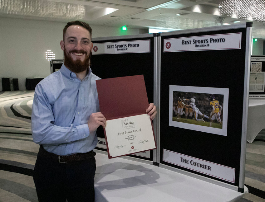 Sports Editor Cole McNanna poses with the first-place award from the Alabama Press Association for best sports photo in Division D at the annual awards banquet Saturday at the Perdido Beach Resort.