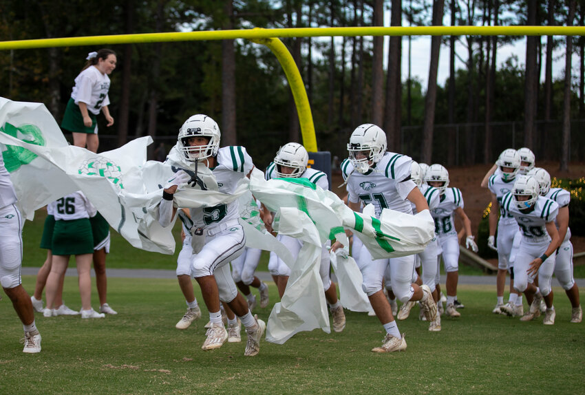 The Bayshore Christian Eagles break through the banner on W.C. Majors Field at Fairhope Municipal Stadium for JV action against the St. Michael Catholic Cardinals on Monday, Sept. 25. It was the team&rsquo;s first game in its hometown of Fairhope although Bayshore Christian served as the away team.