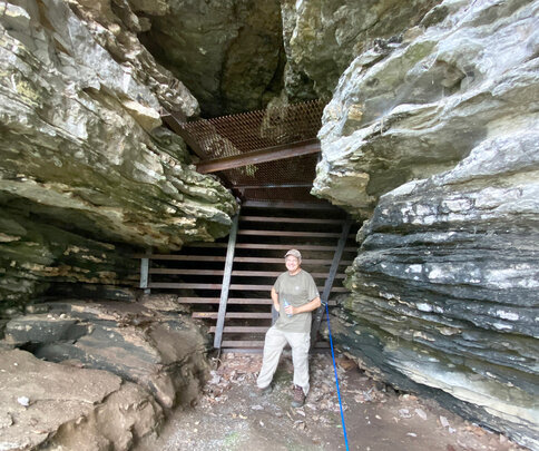 Keith Hudson, a biologist with the Alabama Bat Working Group, stands in front of the completed gate at Bat Cave near Florence