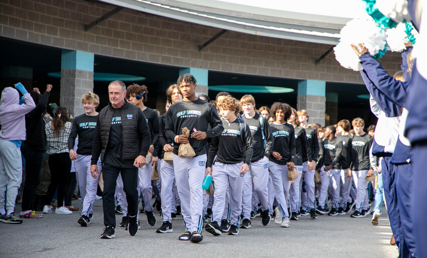 The Gulf Shores Dolphins head for the buses that took them to Tuscaloosa Wednesday morning, Dec. 6, ahead of the AHSAA Class 5A State Championship at Bryant-Denny Stadium Thursday night. The Gulf Shores community gathered at the high school to send them off.