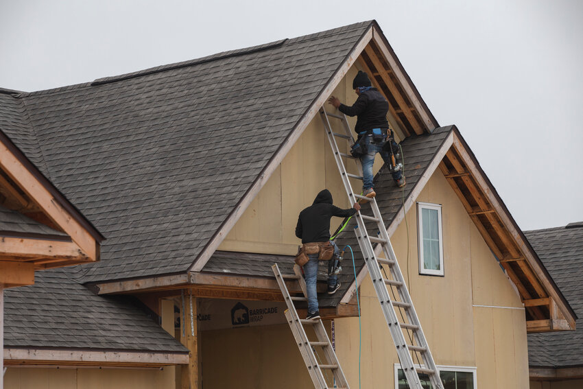 Workers build a house in Foley in 2023.