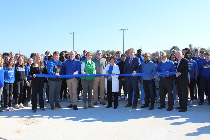 Fairhope High School track and field team members run the inaugural lap on the school's new Track & Field Complex at Founders Park.