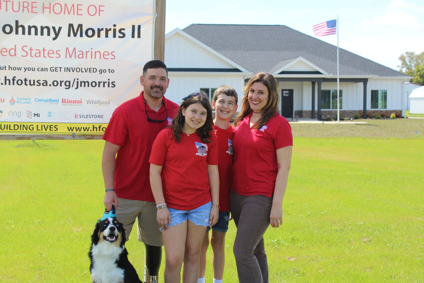 U.S. Marine Corps Staff Sgt. Johnny Morris II, dog Ziggy, daughter Gabby, son Gage, and wife Natalie are home. The Morris family received the keys to their new home Saturday, March 16.