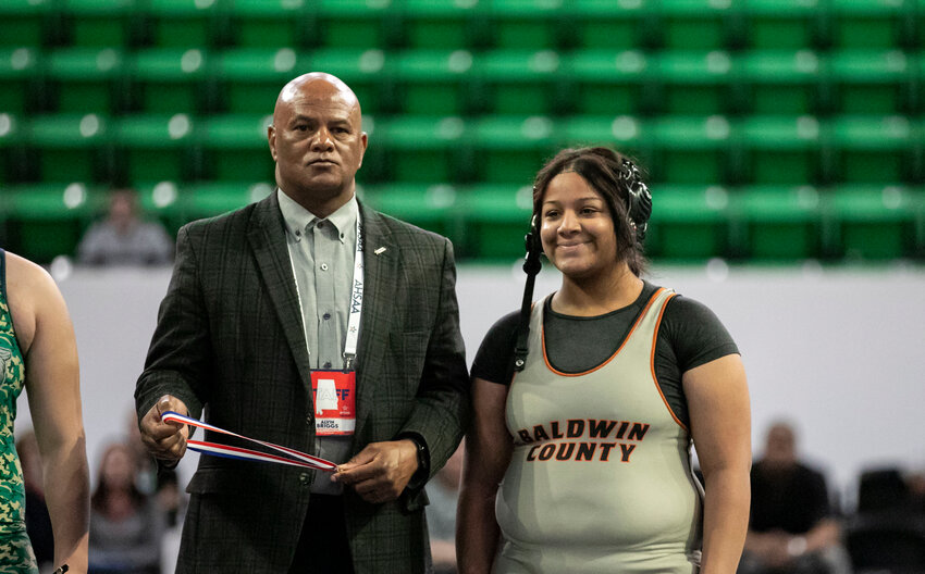 AHSAA Executive Director Alvin Briggs prepares to present a gold medal to Baldwin County&rsquo;s Tamara Reed after her win at the state wrestling championships in Birmingham on Jan. 20, 2023. Briggs announced his retirement, effective Sept. 2, at Wednesday&rsquo;s meeting of the AHSAA Central Board of Control.