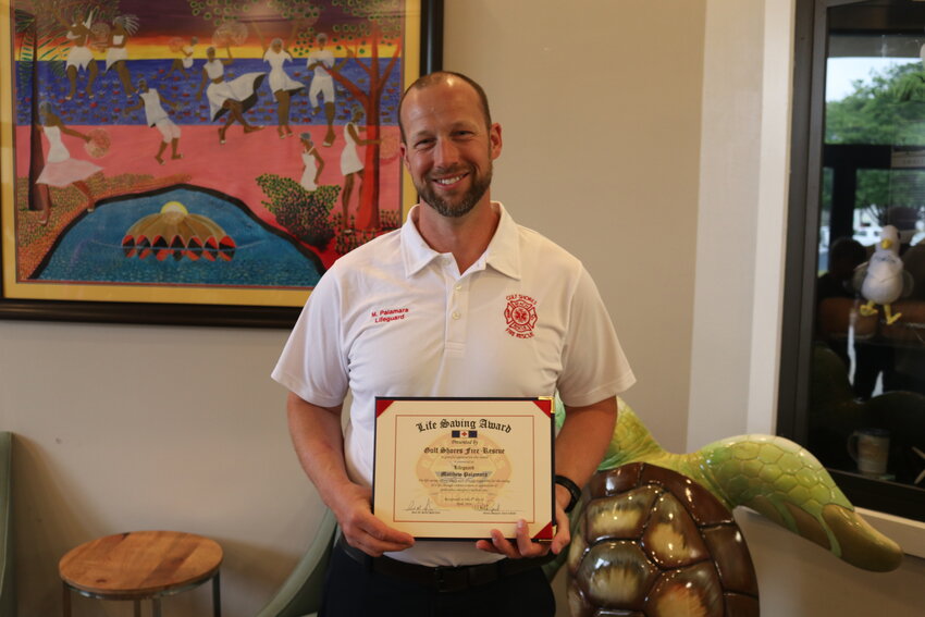 Off-duty lifeguard Matt Palamara, alongside the support of a group of local Boy Scouts, receives a Life Saving Award from Gulf Shores City Council on April 8