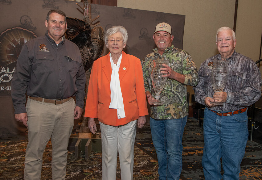 Conservation Commissioner Chris Blankenship joins Governor Kay Ivey to present the Grand Champion trophies to hunter Paul McCaleb, right, and landowner Russ Newman.