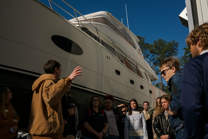 Saunders Yachtworks' decision to consolidate services at its Gulf Shores location marks a strategic move towards enhanced efficiency and centralized customer service in the marine industry. Pictured here is Saunders Yachtworks Director of Operations M. Boyd Siegel as he conducts a tour for juniors and seniors at Gulf Shores High School in March.