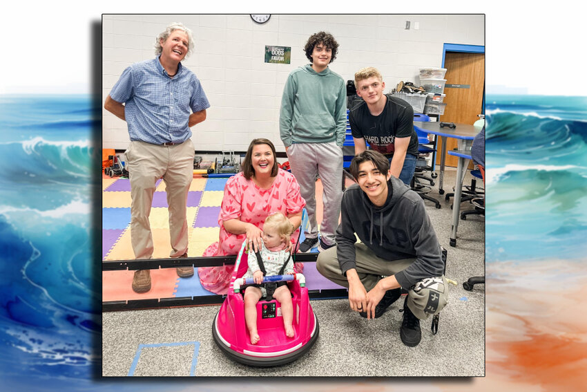 Shreve, her mother, Crawford, and Gulf Shores High School students and teacher James Salvant, gather around the modified bumper car, showcasing the collaborative effort to enhance Shreve's mobility.