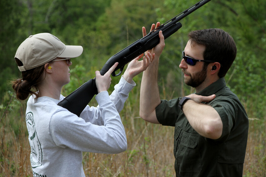 Justin Grider shows Assistant R3 Coordinator Olivia Wilkes the proper point to mount the shotgun.