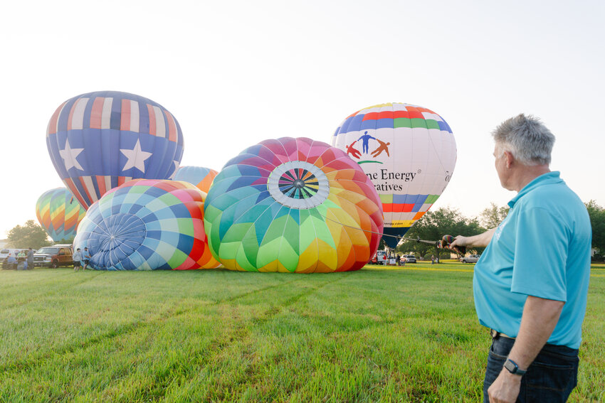 Charles Poole holds onto a rope attached to the top of the Champagne Sunrise balloon.