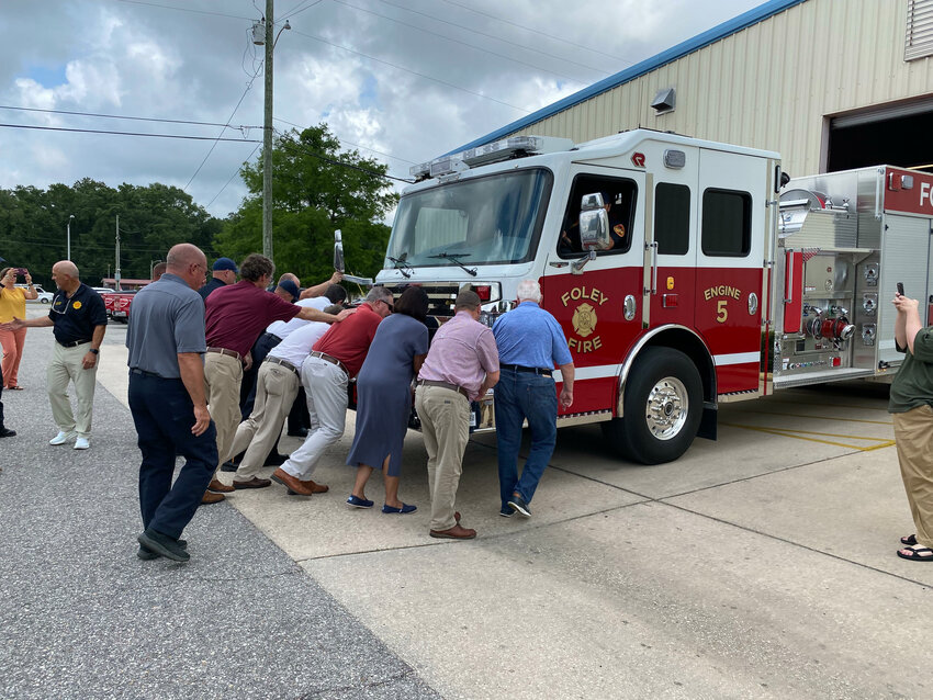 Foley firefighters and officials help push the city&rsquo;s newest pumper truck into the main fire station to mark the unit being placed in active service. The truck will help meet the demand for fire protection services, which have grown 70% in the last five years.