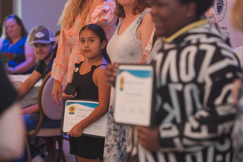 Valeria Angeles stands with her diploma during the South Baldwin Literacy Council&rsquo;s graduation ceremony at the Magnolia Hotel in Foley.