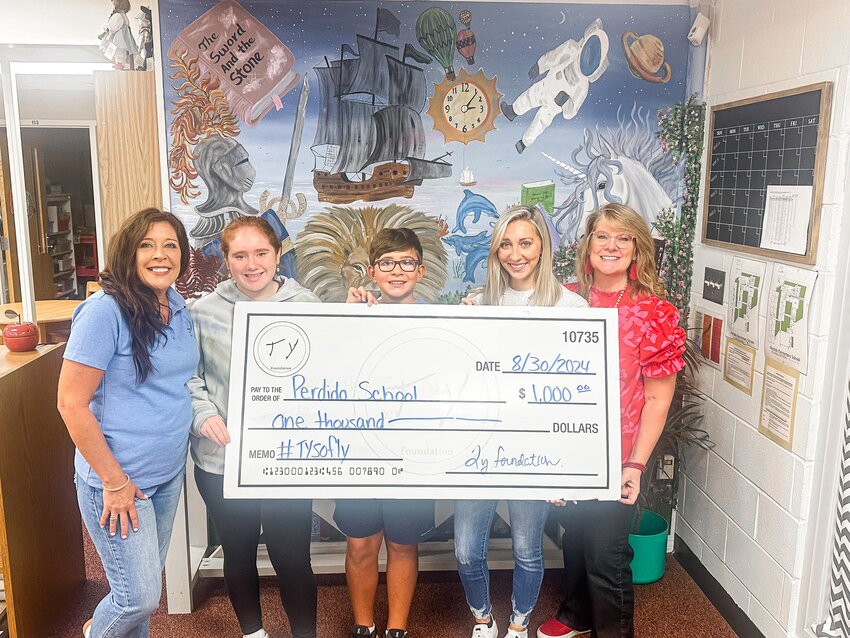 Charlotte Parker, assistant principal, accepts a donation on behalf of Perdido School Athletics from the Ty Foundation. Representing the foundation are Ty Drinkard's mother, Daphne Stamps, along with his siblings Tayler Drinkard, Sophia Drinkard and Miles Stamps.