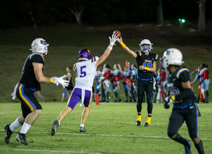 Fairhope’s Jackson Robertson attempts a pass over the outstretched arm of Daphne’s Jace Gibson during the Class 7A Region 1 contest between the Pirates and Trojans at W.C. Majors Field on Oct. 13, 2023. This year’s matchup is heading to Jubilee Stadium in Daphne where Fairhope will be looking to continue the recent trend and improve on a 6-3 lead over the last nine seasons.