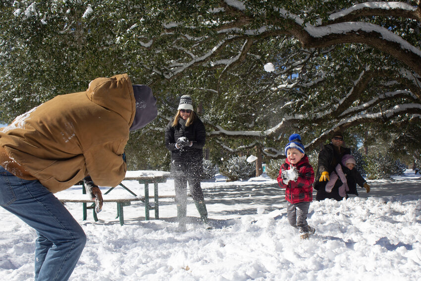 Ashley and Rob Andrews and their son, Ollie, play in a snowball fight Wednesday, Jan. 22, at Meyer Park in Gulf Shores, while Will Hearn and his daughter, Franny, help in the fun.