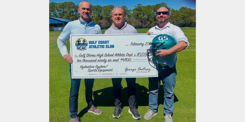 Gulf Shores head football coach Mark Hudspeth was presented with a donation check from George Autrey and Taylor Means from the Gulf Coast Athletic Club before spring practice got underway. The $10,096 check will go toward a hydration system and equipment as the Dolphins gear up for their second season back in Class 6A Region 1.