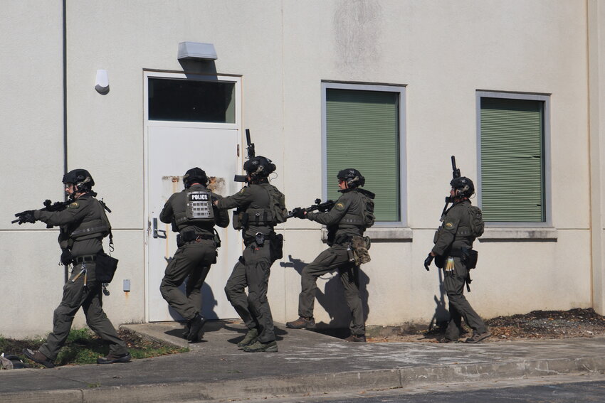 After securing the designated entryway, one of the officers shot the doorknob off and launched several stun grenades into the vacant building.