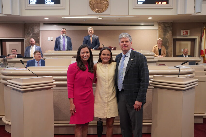 U.S. Sen. Katie Britt, Lulu Gribbin and state Rep. David Faulkner (R-Mountain Brook) pose for a picture in the Alabama House of Representatives chamber when HB 437 is passed.