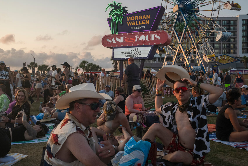 Groups of festival goers sit on the greenspace at Gulf Shores Public Beach, transformed into a Towel and Blanket Zone, during Sand in My Boots music festival on May 17, 2025.