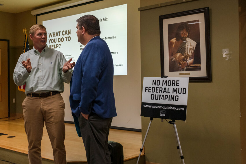 A community member speaks with state Rep. Matt Simpson following the meeting in Fairhope.