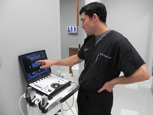 Dr. James Keith Spain uses ultrasound to pinpoint the area in need of therapy.