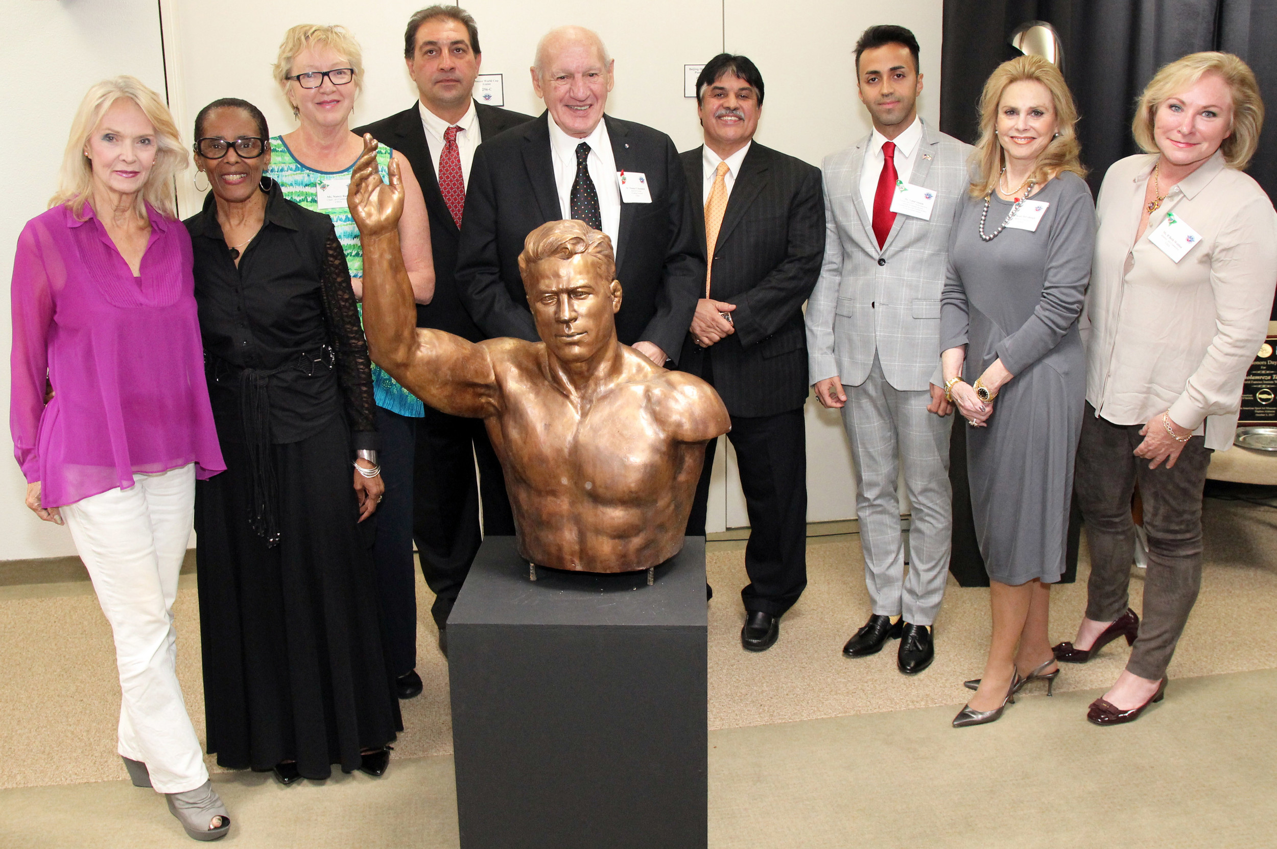 From left are United States Sports Academy’s Art Committee members Kay Daughdrill; B.J. Cooper; and chair Nancy Raia; Babak Takhti, son of the late Jahan Pahlavan Takhti; Academy Founding President and committee member Dr. Thomas P. Rosandich; Ebrahim Maghsoud, NAIFS President and President of the Hafez Corp. in Mobile; Vahid Abideh, NAIFS Founder and CEO and Secretary General of Iran’s Young Journalists Society; committee member emerita and Academy Trustee Susan McCollough; and committee member B’Beth Weldon with sculpture of legendary Iranian wrestler Jahan Pahlavan Takhti presented to the American Sport Art Museum & Archives (ASAMA) by the North American Iranian Friendship Society (NAIFS).
