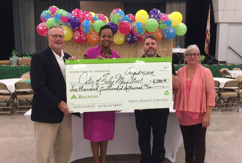 The Regions Bank donation was accepted by (L – R) Ralph Hellmich, Foley City Council; Shirley Sessions, community development manager, Regions Bank; Justin Shanks, vice-president, Foley Main Street; and Miriam Boutwell, acting director, Foley Main Street.