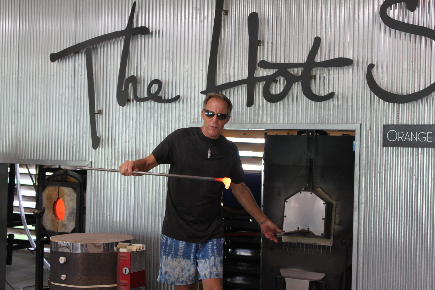 Bill Bollinger gathers molten glass from the furnace in The Hot Shop.