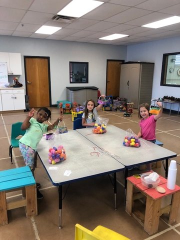Making Easter baskets with bags of eggs given to the Y by OWA.