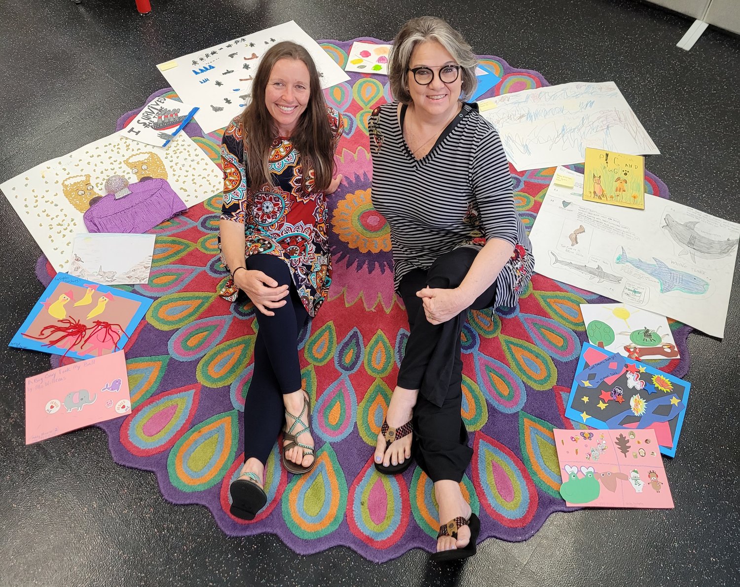 Anna Hallex and Kelley Wansley, of the Children's Department at the Library, surrounded by April's "Read A Book" project entries.