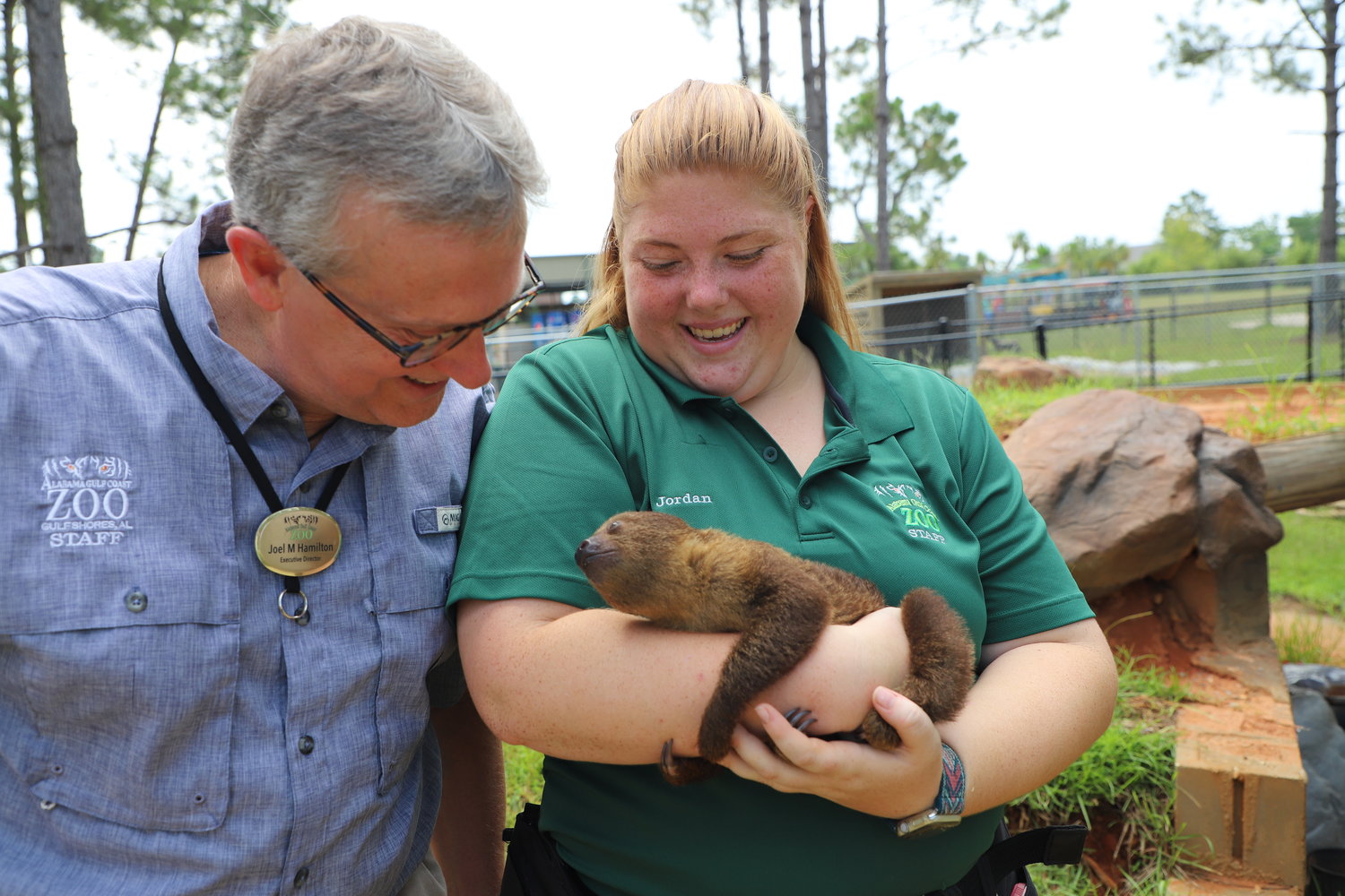 Alabama Gulf Coast Zoo Executive Director Joel Hamilton and Jordan Danflous, a guest engagement keeper, admire the zoo’s newest addition, a three-month-old Southern two-toed sloth.