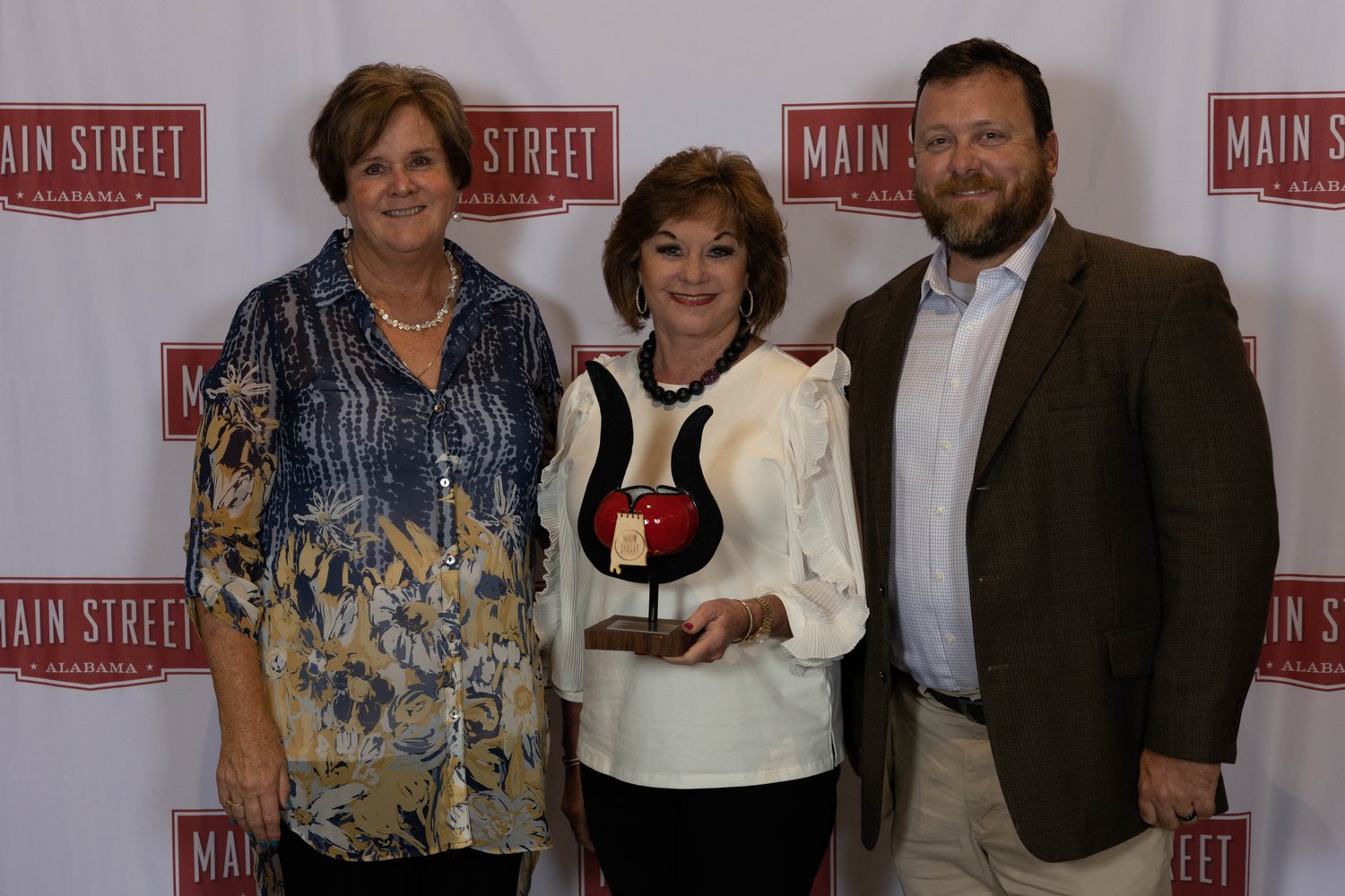 Executive Director Darrelyn Dunmore, Board Member Frances Holk-Jones, and President Chad Watkins accepted the awards at the Main Street Alabama Awards Banquet.