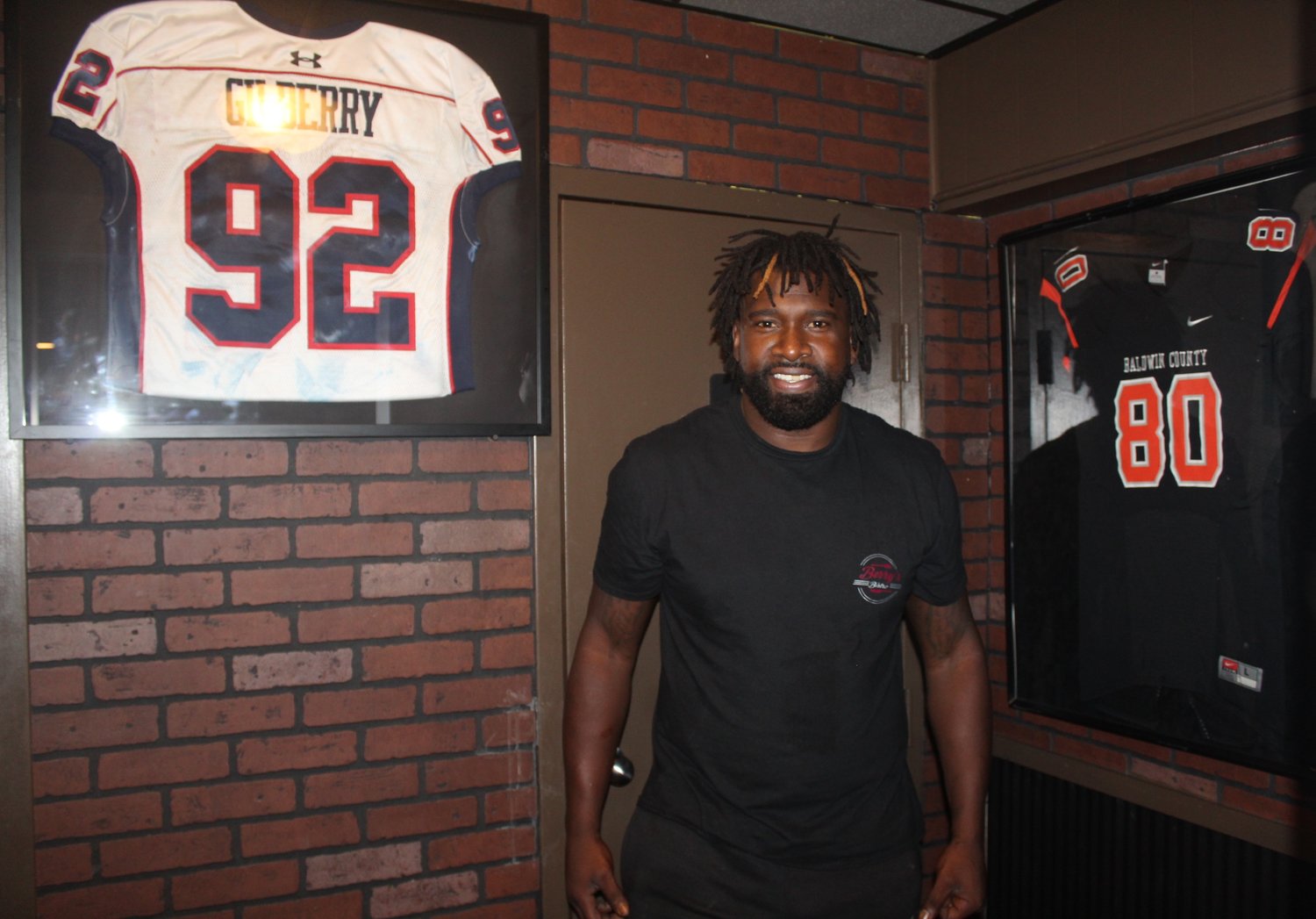 Jerseys line the walls at Berry’s Bistro, including two that started it all, Wallace Gilberry’s retired jersey from Baldwin County High School and his jersey from the Alabama-Mississippi All-Star game.