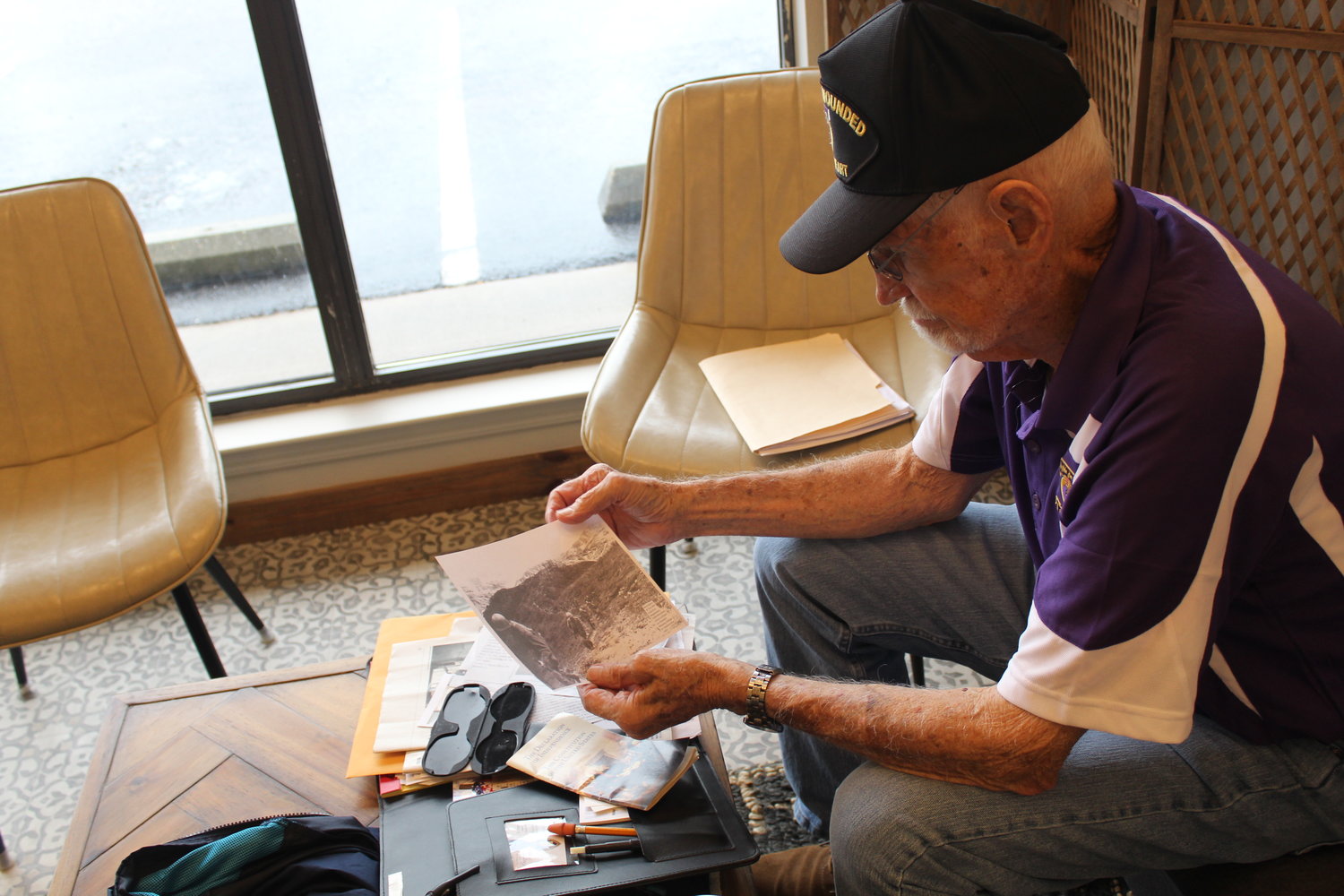 Silverhill resident Ed Evans looks over photos from his time in Korea and his invitation to represent the state of Alabama in the 2021 Purple Heart Patriot Project Sept. 27-30 in New York.