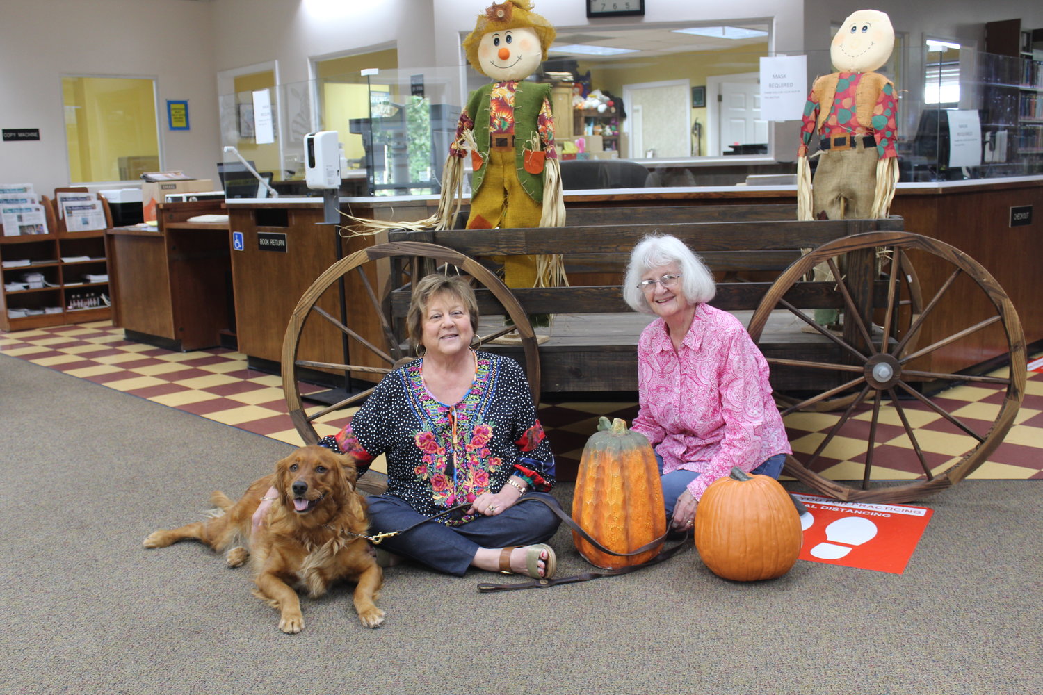 Robertsdale Library Director Cynthia Nall, assistant Liz Silcox and resident canine Gracie May get ready for Halloween Fun Night Thursday, Oct. 21 at the Library.