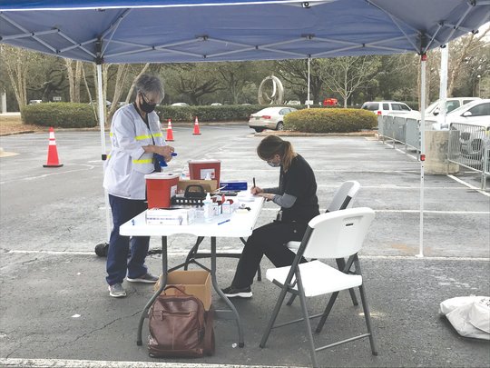 Alabama Department of Public Health workers prepare vaccines to be administered at a drive-through clinic at the Daphne Civic Center in early 2021. Health care workers spent much of 2021 dealing with the impact of COVID-19.